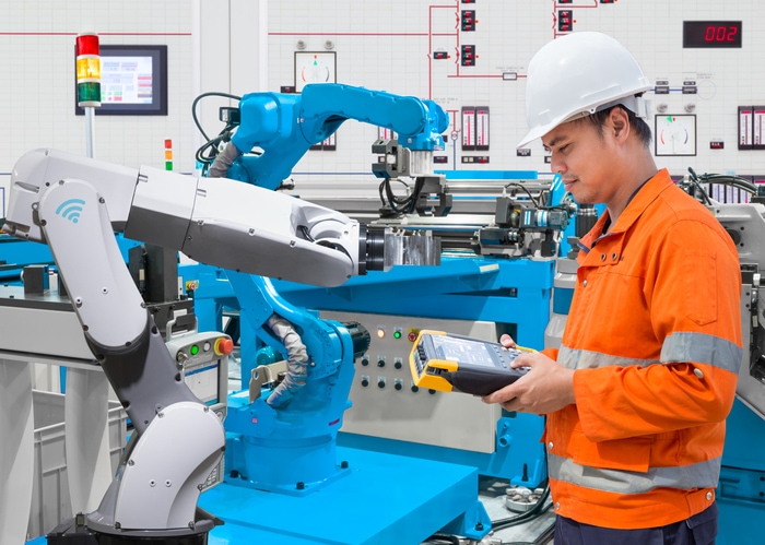 Maintenance engineer programming automated robotic at industry 4.0 concept