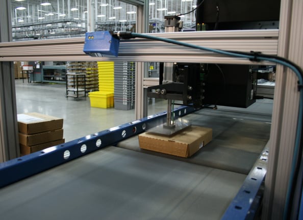 Robot preparing a package and applying a label