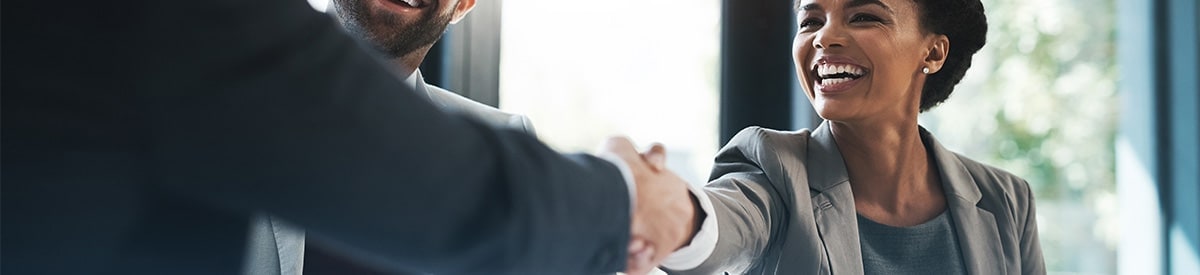 Un hombre de negocios le da la mano a una mujer de negocios